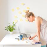 Person focused on completing tasks at a desk with planner, laptop, and coffee, representing productivity and overcoming procrastination
